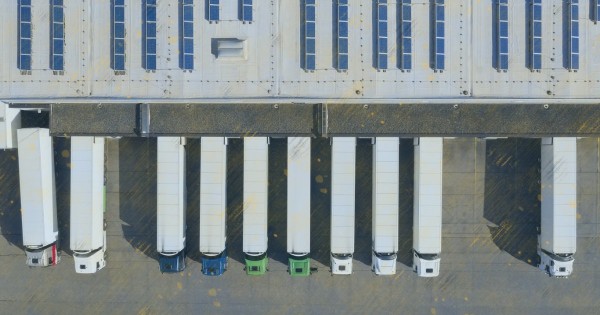 Aerial view of cargo containers, semi trailers, industrial warehouse, storage building and loading docks, renewable energy plants, Bavaria, Germany